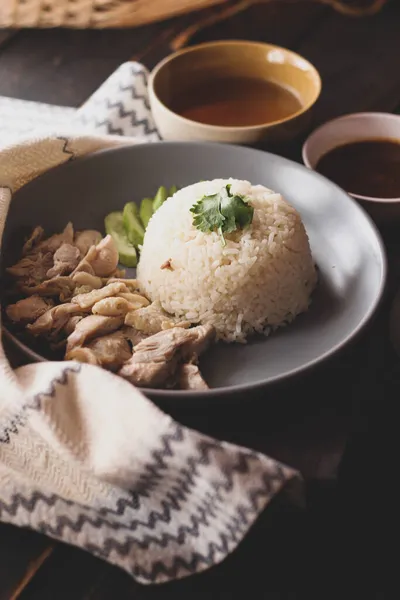 黒木のテーブルの上に醤油と熱いスープを添えた海南鶏飯 — ストック写真