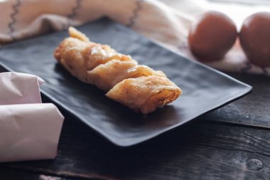 Roti, un ve yumurtadan yapılmış Hint yemeği. Siyah bir tabakta tatlandırılmış sütle servis edilir..