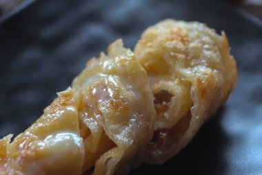 Roti, un ve yumurtadan yapılmış Hint yemeği. Siyah bir tabakta tatlandırılmış sütle servis edilir..