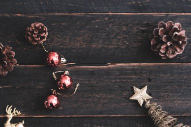 Siyah ahşap bir masaya yerleştirilmiş Noel süslerinin en üst görüntüsü.