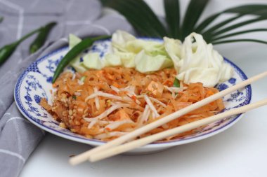 Tayland yemeği Pad Thai (ulusal yemek) Çin usulü bir kasede servis edilir. Beyaz bir masaya koy..