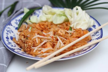Tayland yemeği Pad Thai (ulusal yemek) Çin usulü bir kasede servis edilir. Beyaz bir masaya koy..
