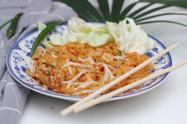 Tayland yemeği Pad Thai (ulusal yemek) Çin usulü bir kasede servis edilir. Beyaz bir masaya koy..