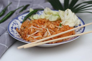 Tayland yemeği Pad Thai (ulusal yemek) Çin usulü bir kasede servis edilir. Beyaz bir masaya koy..