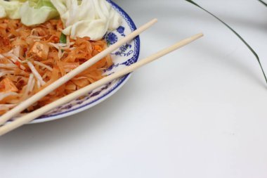 Tayland yemeği Pad Thai (ulusal yemek) Çin usulü bir kasede servis edilir. Beyaz bir masaya koy..
