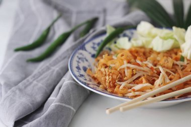 Tayland yemeği Pad Thai (ulusal yemek) Çin usulü bir kasede servis edilir. Beyaz bir masaya koy..