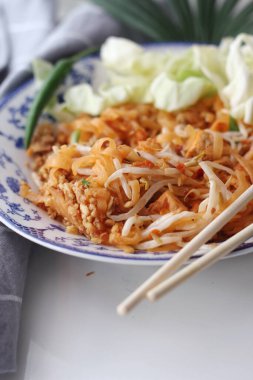 Tayland yemeği Pad Thai (ulusal yemek) Çin usulü bir kasede servis edilir. Beyaz bir masaya koy..
