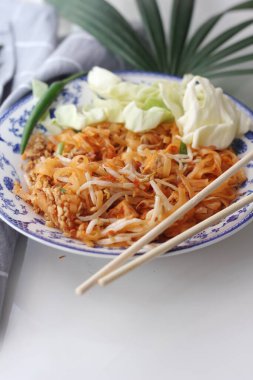 Tayland yemeği Pad Thai (ulusal yemek) Çin usulü bir kasede servis edilir. Beyaz bir masaya koy..
