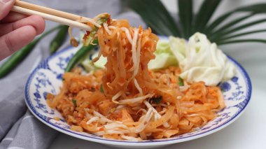 Tayland yemeği Pad Thai (ulusal yemek) Çin usulü bir kasede servis edilir. Beyaz bir masaya koy..