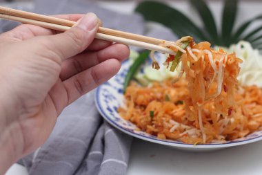 Tayland yemeği Pad Thai (ulusal yemek) Çin usulü bir kasede servis edilir. Beyaz bir masaya koy..