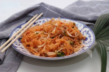 Tayland yemeği Pad Thai (ulusal yemek) Çin usulü bir kasede servis edilir. Beyaz bir masaya koy..
