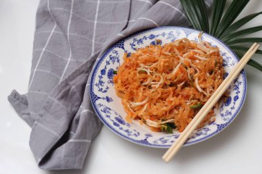 Tayland yemeği Pad Thai (ulusal yemek) Çin usulü bir kasede servis edilir. Beyaz bir masaya koy..