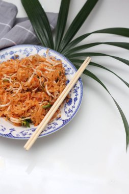 Tayland yemeği Pad Thai (ulusal yemek) Çin usulü bir kasede servis edilir. Beyaz bir masaya koy..