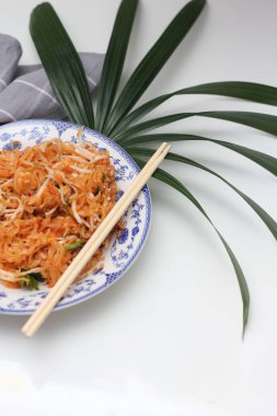 Tayland yemeği Pad Thai (ulusal yemek) Çin usulü bir kasede servis edilir. Beyaz bir masaya koy..