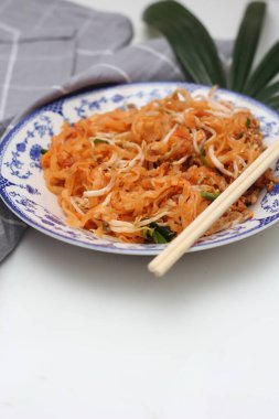 Tayland yemeği Pad Thai (ulusal yemek) Çin usulü bir kasede servis edilir. Beyaz bir masaya koy..