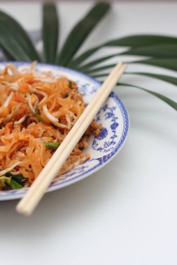 Tayland yemeği Pad Thai (ulusal yemek) Çin usulü bir kasede servis edilir. Beyaz bir masaya koy..