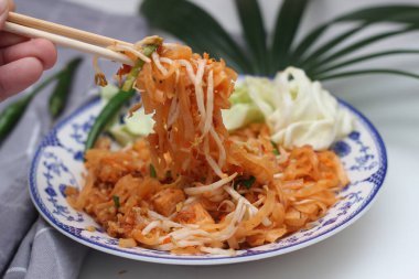 Tayland yemeği Pad Thai (ulusal yemek) Çin usulü bir kasede servis edilir. Beyaz bir masaya koy..