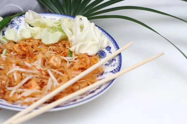 Tayland yemeği Pad Thai (ulusal yemek) Çin usulü bir kasede servis edilir. Beyaz bir masaya koy..