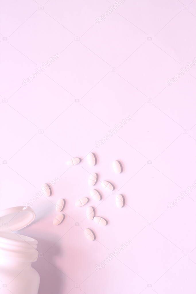 White pills and pill bottles were placed on a white table.
