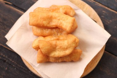 Kızarmış geleneksel Tayland hamur çubuğu siyah ahşap bir masada servis edilir. Genel olarak Taylandlılar için kahvaltı..