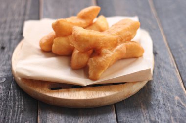 Kızarmış geleneksel Tayland hamur çubuğu siyah ahşap bir masada servis edilir. Genel olarak Taylandlılar için kahvaltı..