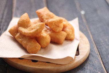 Kızarmış geleneksel Tayland hamur çubuğu siyah ahşap bir masada servis edilir. Genel olarak Taylandlılar için kahvaltı..