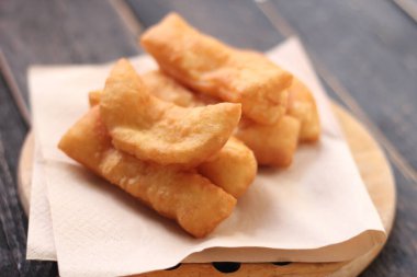 Kızarmış geleneksel Tayland hamur çubuğu siyah ahşap bir masada servis edilir. Genel olarak Taylandlılar için kahvaltı..