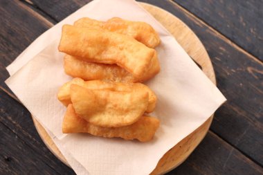 Kızarmış geleneksel Tayland hamur çubuğu siyah ahşap bir masada servis edilir. Genel olarak Taylandlılar için kahvaltı..