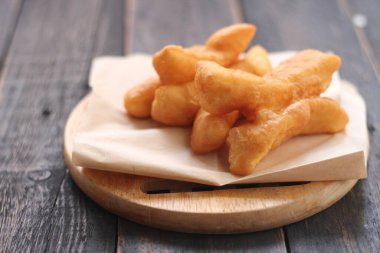 Kızarmış geleneksel Tayland hamur çubuğu siyah ahşap bir masada servis edilir. Genel olarak Taylandlılar için kahvaltı..