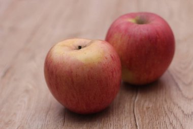 Tahta bir masaya iki elma, vücuda yararlı C vitamini içeren meyveler..