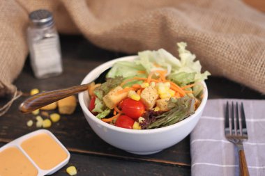 Sezar salatası ve Sezar sosu. Siyah ahşap bir masada.