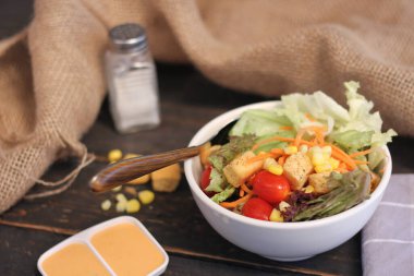 Sezar salatası ve Sezar sosu. Siyah ahşap bir masada.