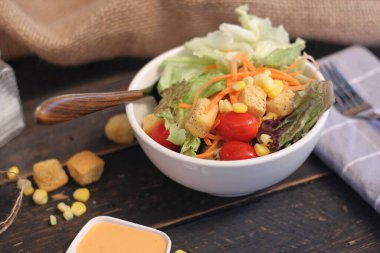 Sezar salatası ve Sezar sosu. Siyah ahşap bir masada.