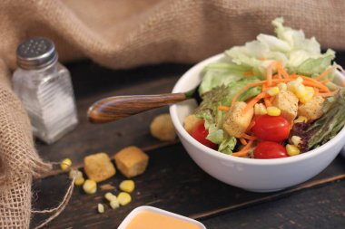 Sezar salatası ve Sezar sosu. Siyah ahşap bir masada.