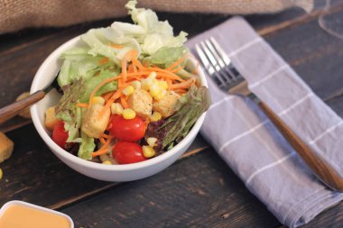 Sezar salatası ve Sezar sosu. Siyah ahşap bir masada.