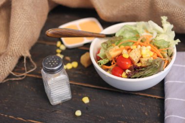 Sezar salatası ve Sezar sosu. Siyah ahşap bir masada.