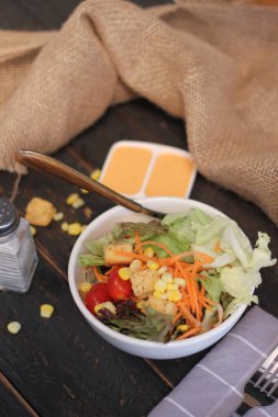 Sezar salatası ve Sezar sosu. Siyah ahşap bir masada.