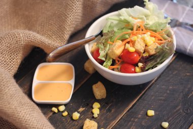 Sezar salatası ve Sezar sosu. Siyah ahşap bir masada.