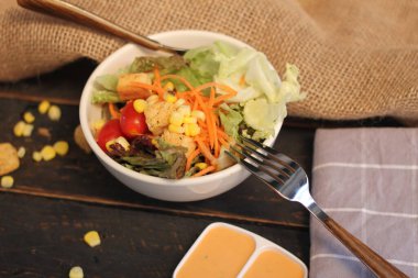 Sezar salatası ve Sezar sosu. Siyah ahşap bir masada.