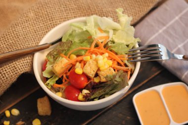 Sezar salatası ve Sezar sosu. Siyah ahşap bir masada.