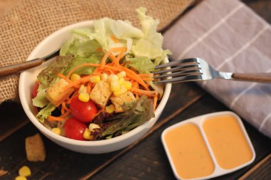 Sezar salatası ve Sezar sosu. Siyah ahşap bir masada.