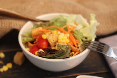 Sezar salatası ve Sezar sosu. Siyah ahşap bir masada.