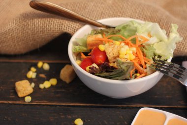 Sezar salatası ve Sezar sosu. Siyah ahşap bir masada.