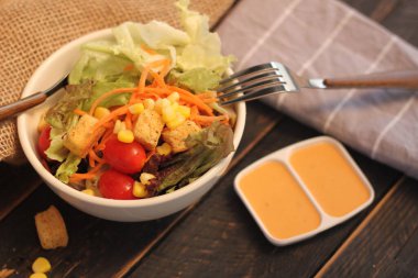 Sezar salatası ve Sezar sosu. Siyah ahşap bir masada.