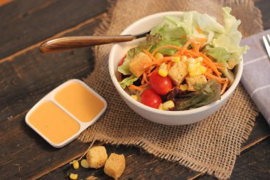 Sezar salatası ve Sezar sosu. Siyah ahşap bir masada.