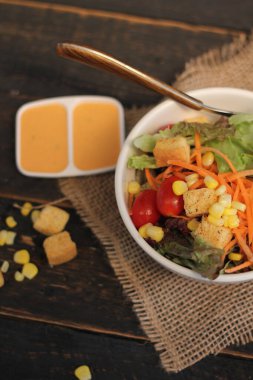 Sezar salatası ve Sezar sosu. Siyah ahşap bir masada.