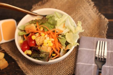 Sezar salatası ve Sezar sosu. Siyah ahşap bir masada.