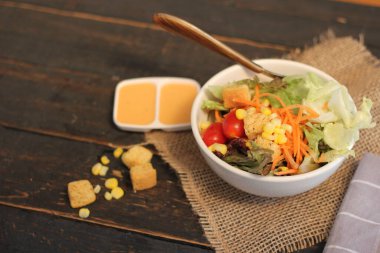 Sezar salatası ve Sezar sosu. Siyah ahşap bir masada.