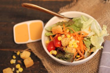 Sezar salatası ve Sezar sosu. Siyah ahşap bir masada.