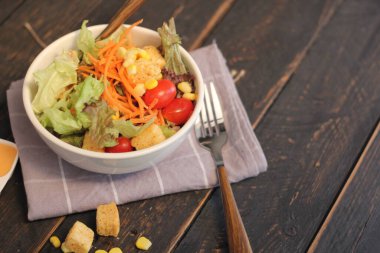 Sezar salatası ve Sezar sosu. Siyah ahşap bir masada.